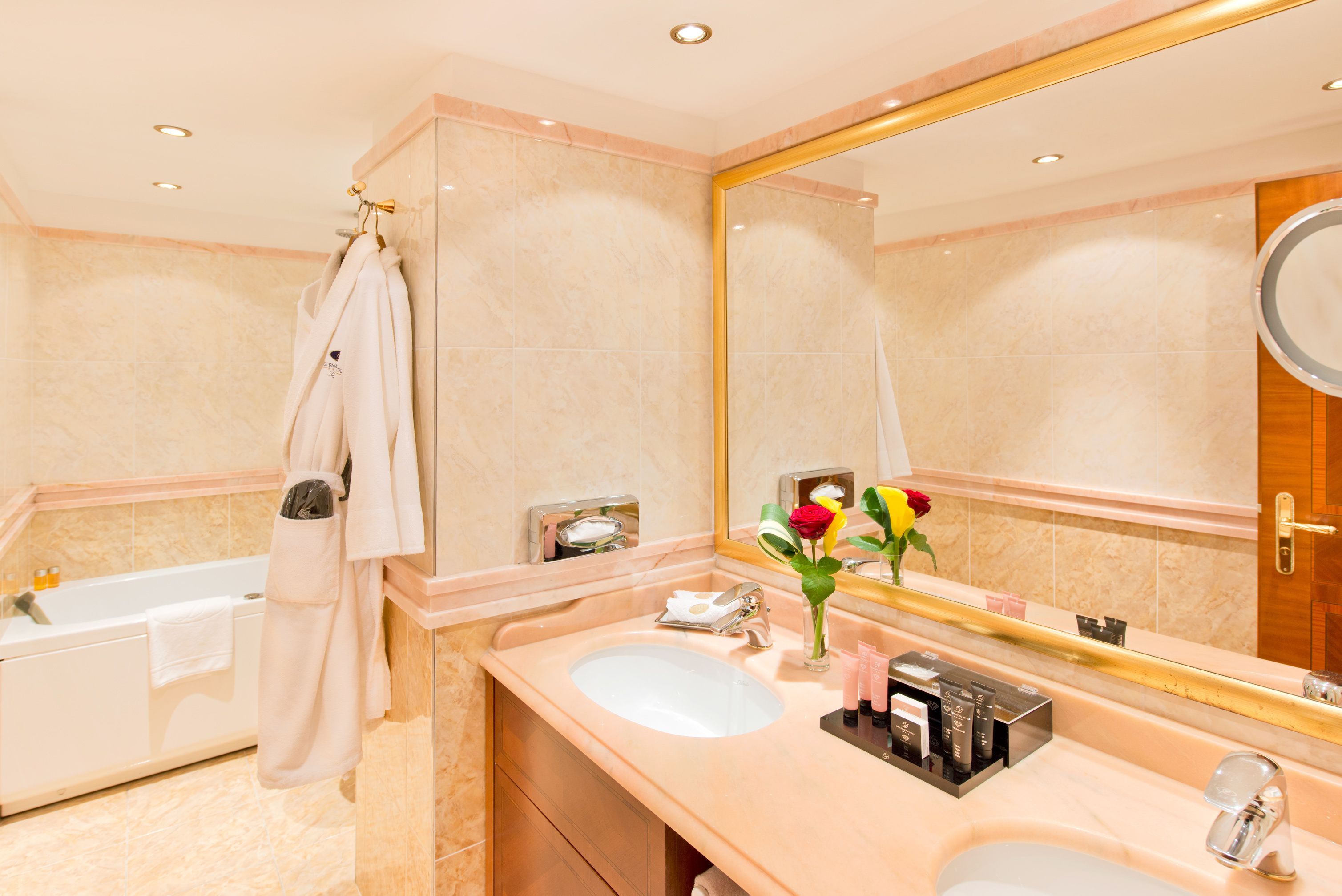 A modern bathroom with a bathtub, a large mirror, and a vanity with a sink.