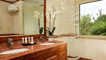 Un bagno con due lavandini, uno specchio grande e un'orchidea in vaso.