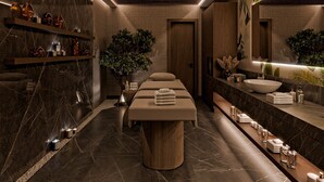 Un spa moderno con una mesa de masaje central, un espejo grande y un tocador con lavabo.