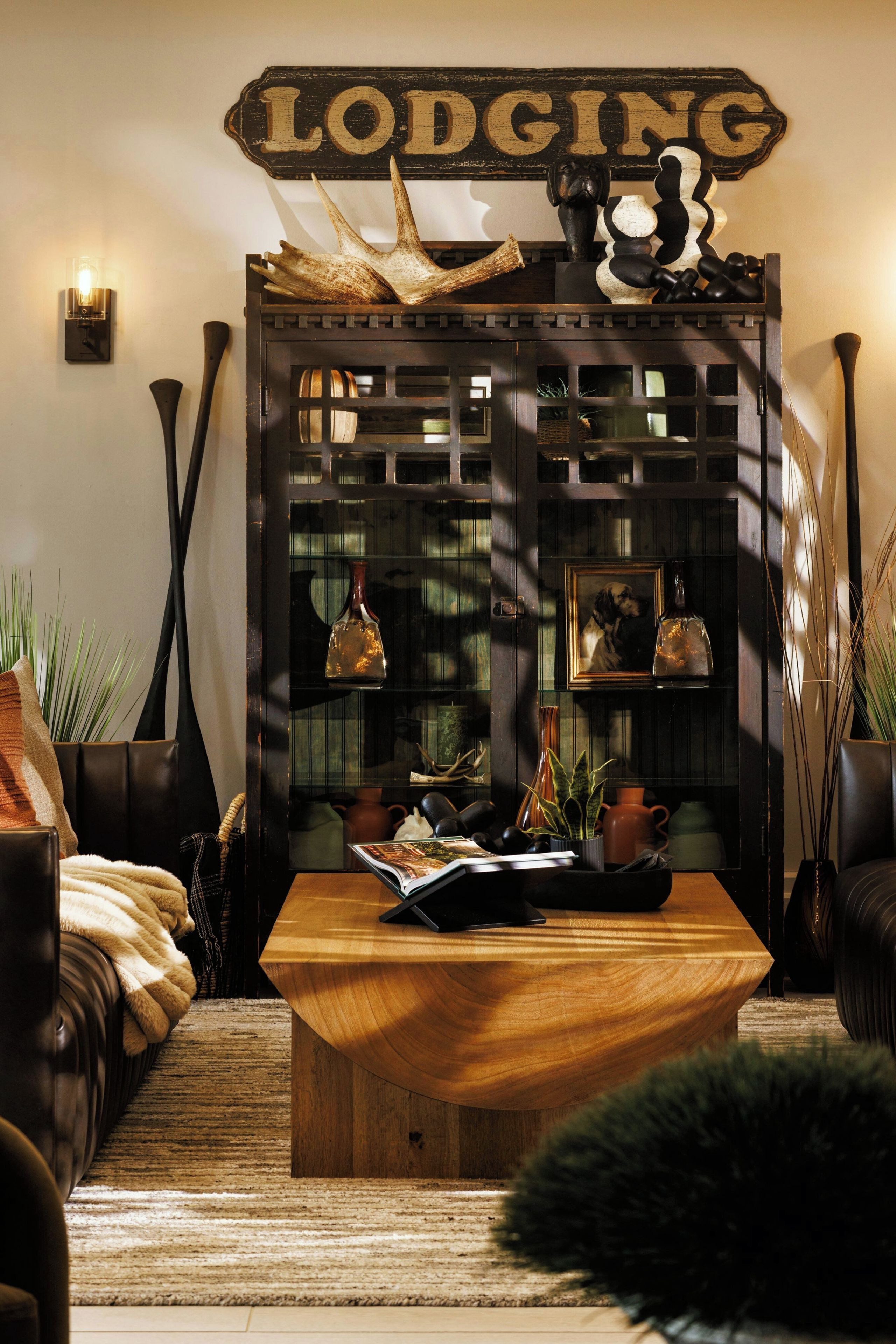 A cozy living room with a wooden coffee table, leather sofas, and a decorative wall sign.