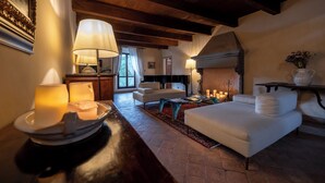Un accogliente soggiorno con camino, divani bianchi e soffitto in legno.