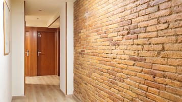 Un pasillo con pared de ladrillo y puertas de madera.