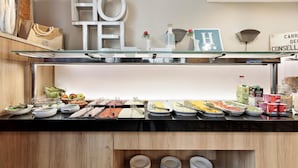 A buffet setup with various food items and utensils.
