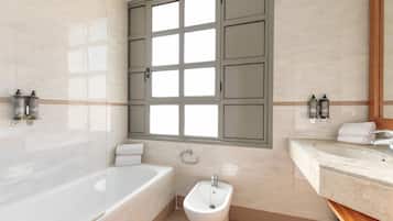 Une salle de bain moderne équipée d’une baignoire, d’un bidet et d’un meuble-lavabo.