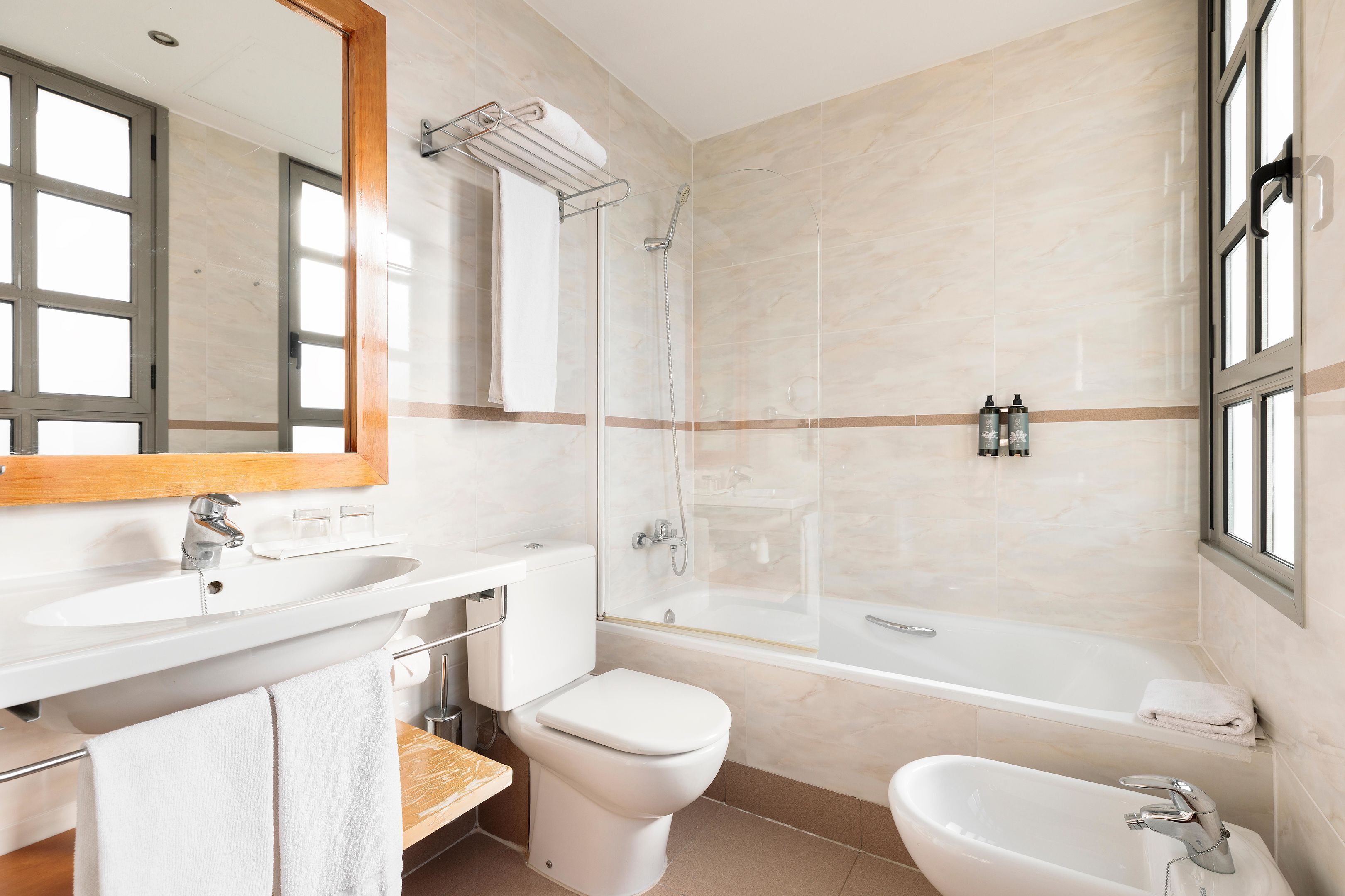 Un baño moderno con lavamanos, inodoro, bañera y ducha.
