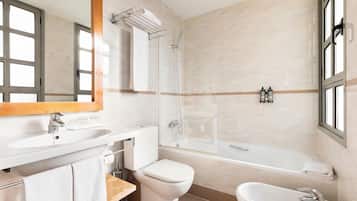 Un baño moderno con lavamanos, inodoro, bañera y ducha.