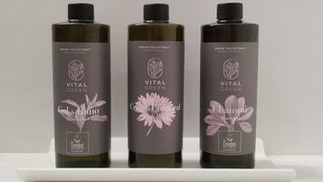 Tre bottiglie di prodotti Vital Green su uno scaffale bianco.