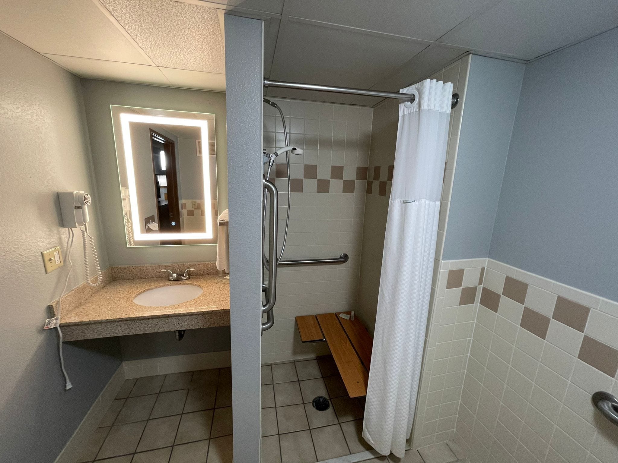 A bathroom with a sink, mirror, shower, and toilet.