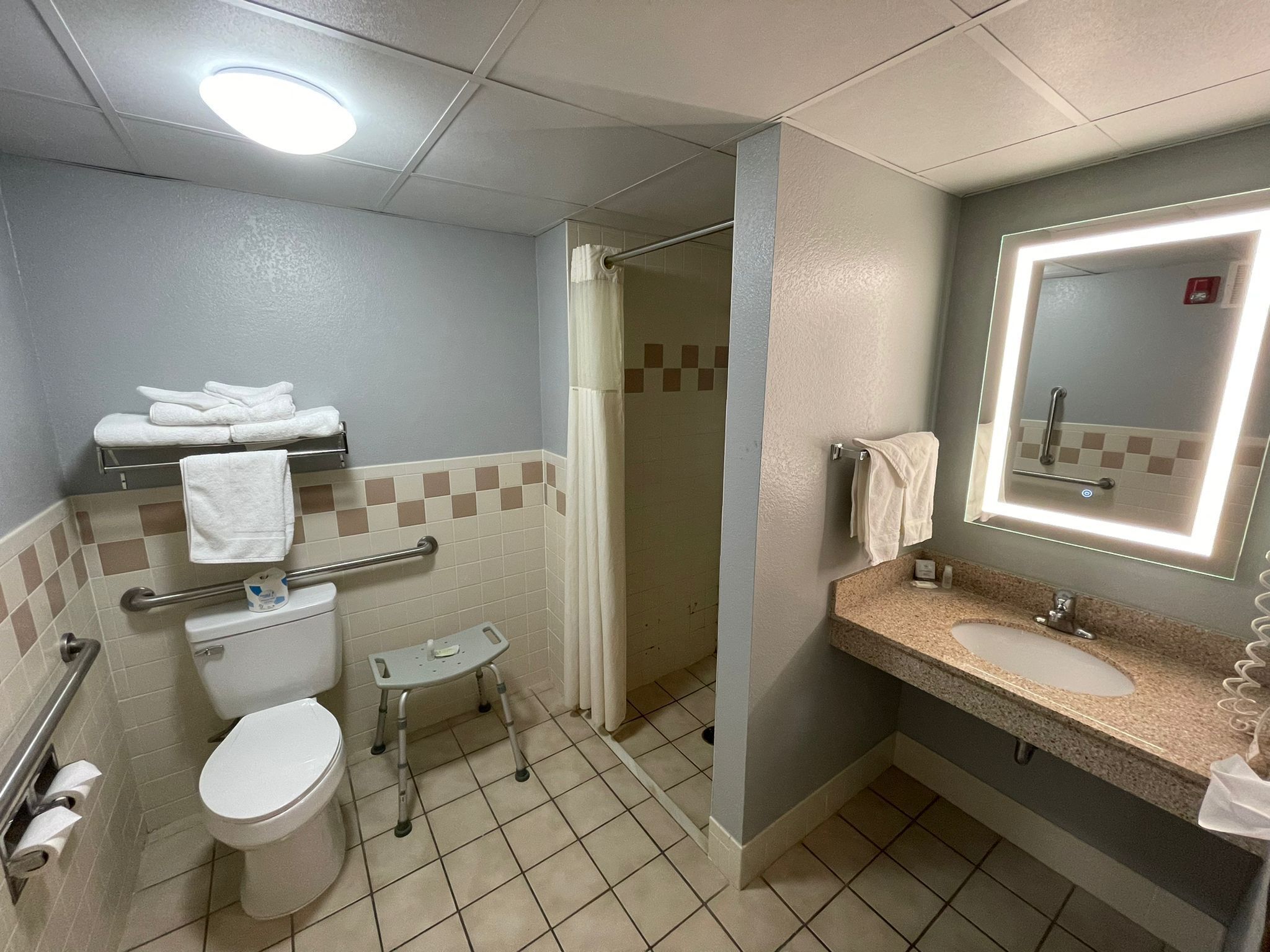 Un bany amb vàter, un lavabo, un mirall i una dutxa.