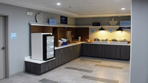 A modern kitchen with a built-in refrigerator, a sink, and a microwave. There are cabinets and a countertop with various kitchen items. - Holiday Inn Express & Suites Enterprise by IHG (Enterprise)