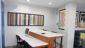 A conference room with a long table, chairs, a laptop, and two framed artworks on the wall. - Holiday Inn Express & Suites Enterprise by IHG (Enterprise)