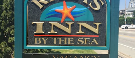 A sign for Rhea's Inn by the sea with a starfish emblem.