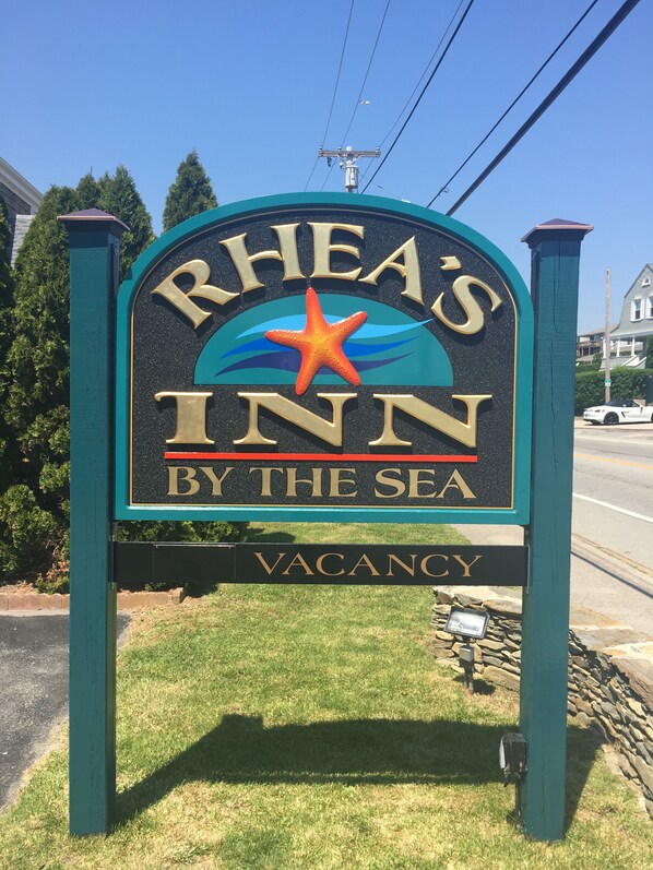 Une enseigne pour l’auberge de Rhea, située en bord de mer, avec un emblème représentant une étoile de mer.
