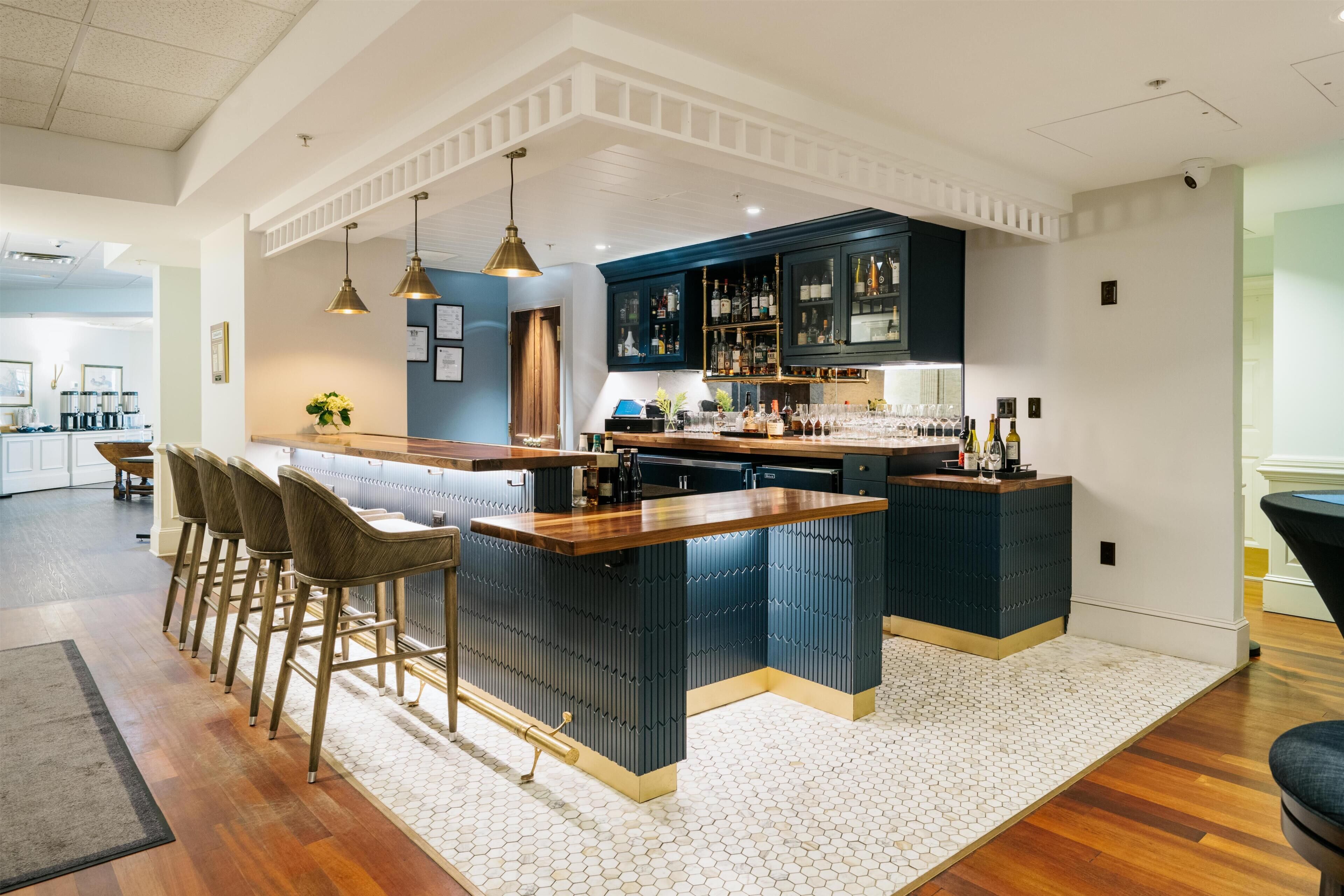 A modern kitchen with a central island, bar stools, and a built-in wine rack.