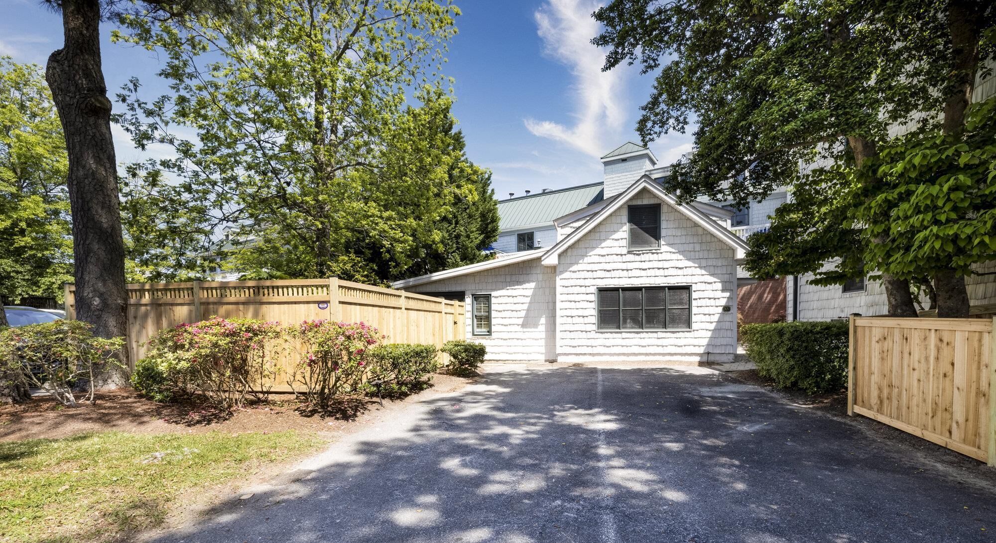 A single-story house with a sloped roof, a front porch, and a driveway leading to the entrance.