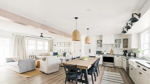 A modern kitchen with a wooden dining table, black chairs, and pendant lights. - The Bellmoor Inn & Spa (Rehoboth Beach)