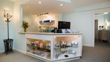 Un espace d’accueil avec un comptoir où sont exposés divers objets, un téléviseur et un vase décoratif.