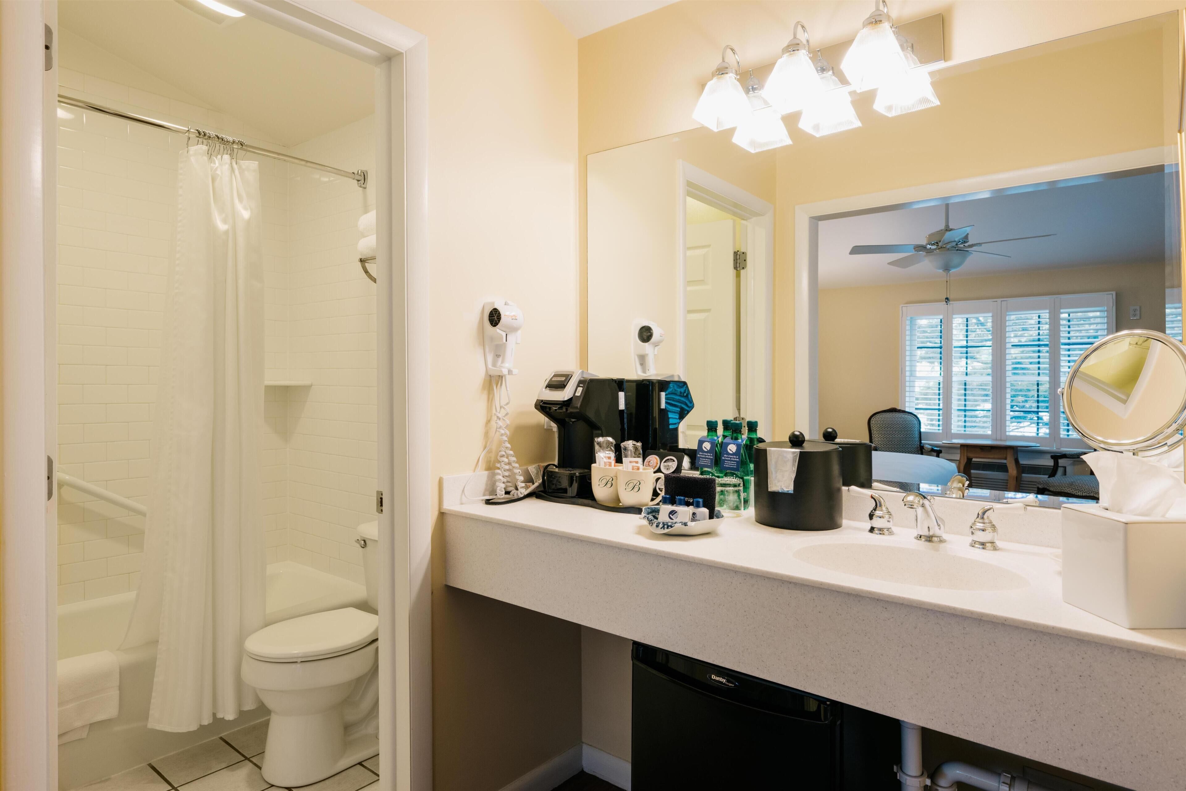 A bathroom with a shower, toilet, and sink area.