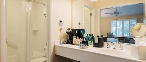 A bathroom with a shower, toilet, and sink area.