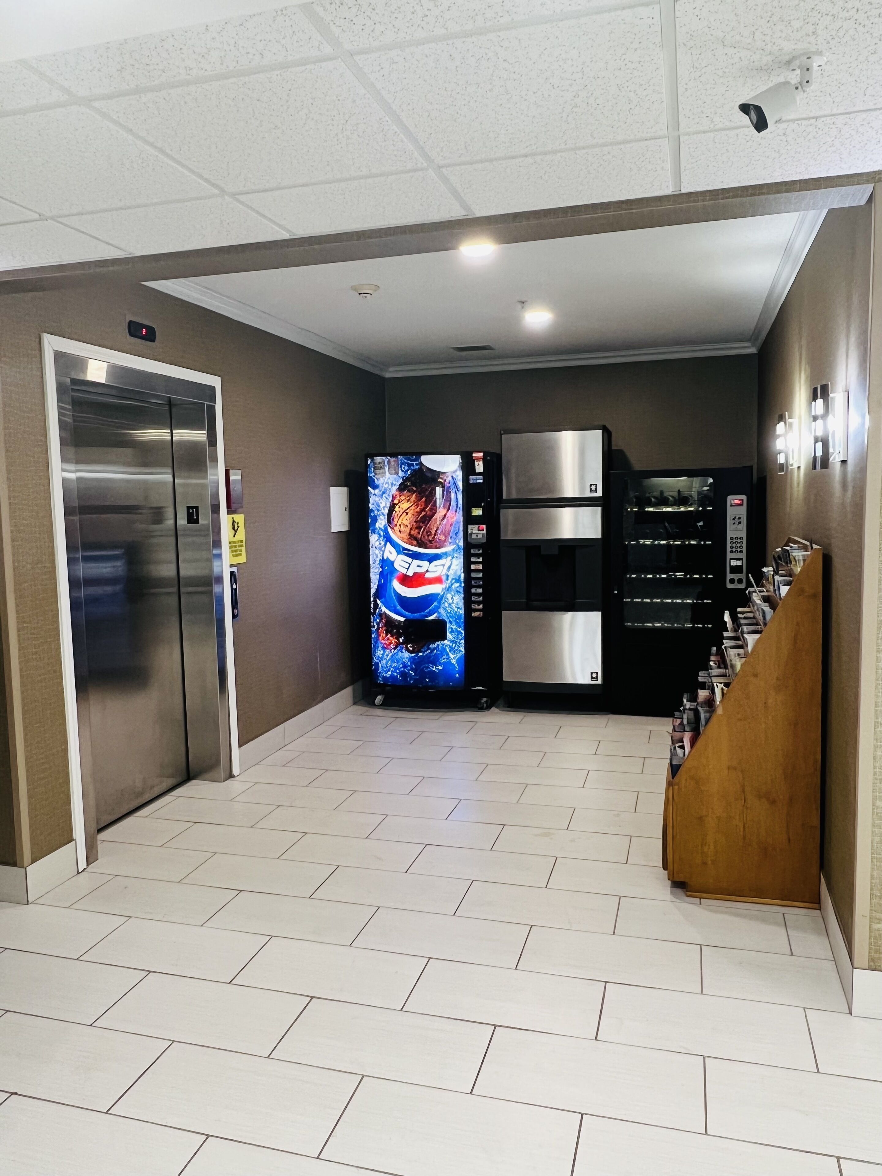 Una hall moderna e pulita con distributore automatico, forno a microonde e ascensore.