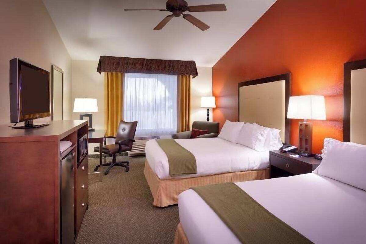 أغطية فراش متميزة وخزنة داخل الغرفة ومكتب ومساحة عمل للكمبيوتر المحمول