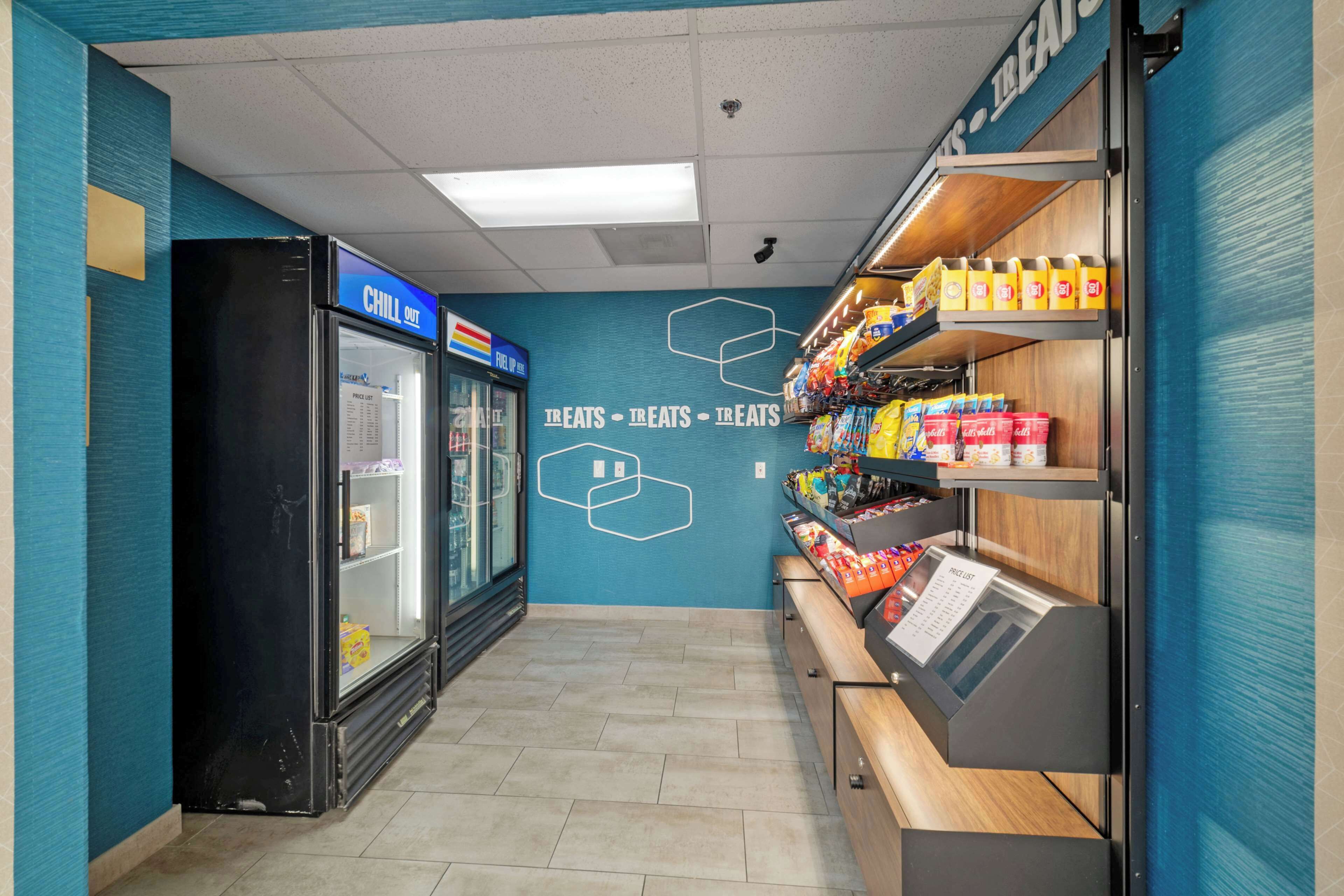 A snack bar with a refrigerated display and shelves stocked with snacks.