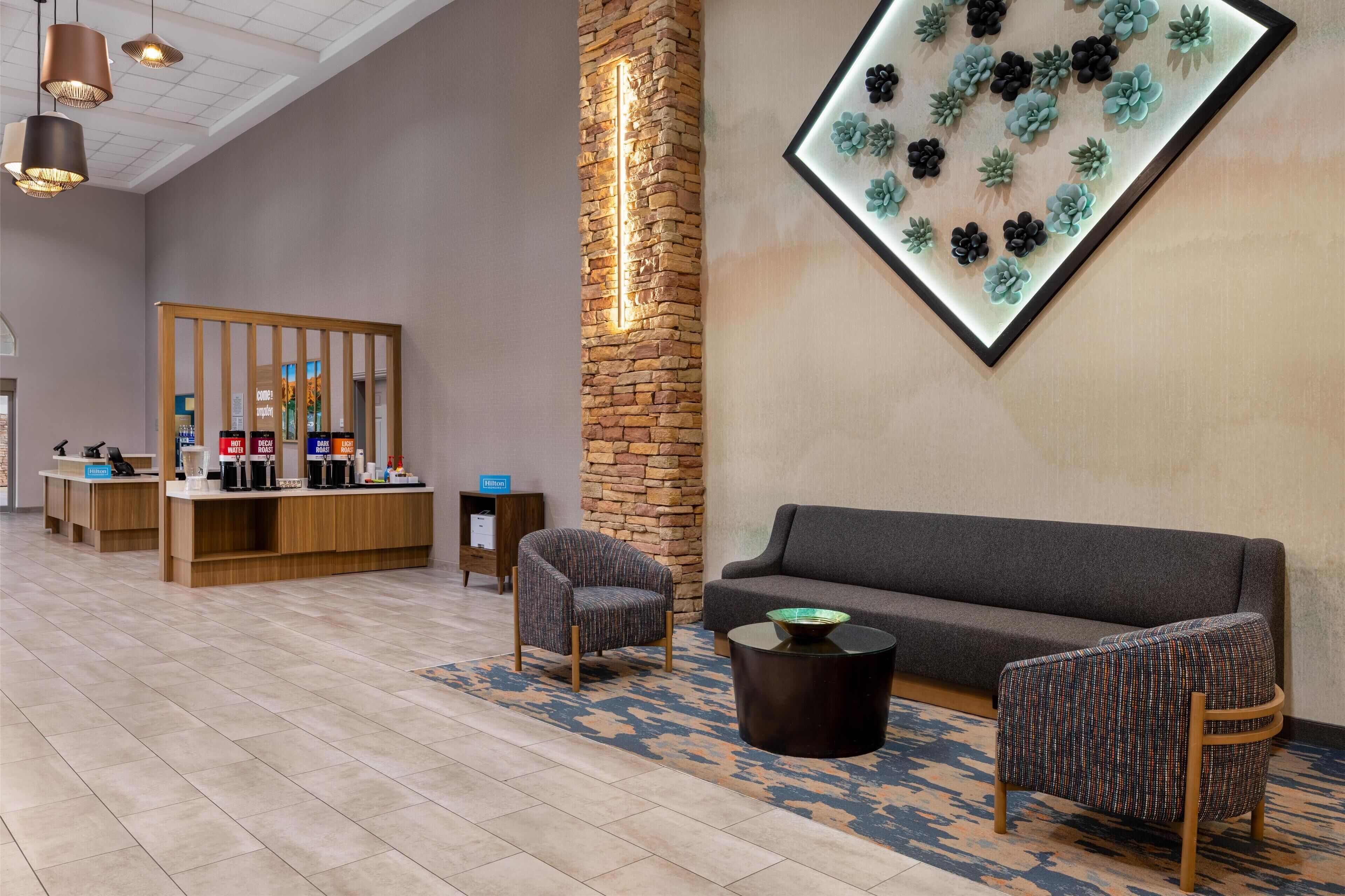 A lobby with a reception desk, seating area, and a wall-mounted light fixture.