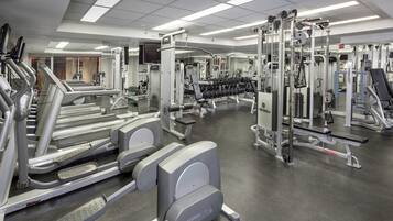 A gym with treadmills, weight machines, and free weights.
