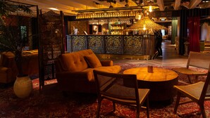 A bar area with a round table and chairs, a sofa, and a decorative plant. - Hotell Arkipelag (Mariehamn)