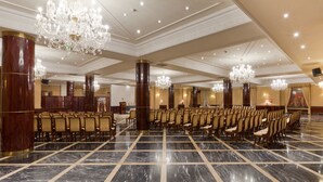 A spacious hall with rows of chairs, large chandeliers, and marble flooring. - Alameda Palace (Salamanca)