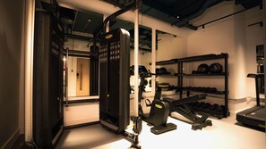 A gym with weightlifting equipment, a treadmill, and a mirror. - Holiday Inn London Camden Lock by IHG (London)