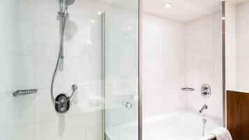 A modern bathroom with a glass-enclosed shower, a separate bathtub, and a wooden vanity.