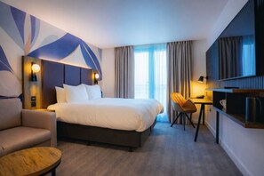 A modern hotel room with a large bed, a desk, a chair, and a TV. - Holiday Inn London Camden Lock by IHG (London)