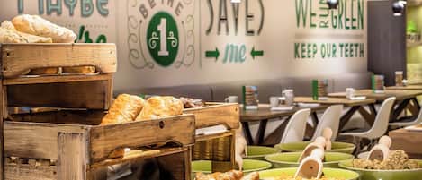 A bakery display with various baked goods and a wall with motivational phrases.