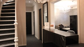 A hotel lobby with a staircase, a reception desk, and a chandelier. - Sara's Boutique Hotel (Amsterdam)