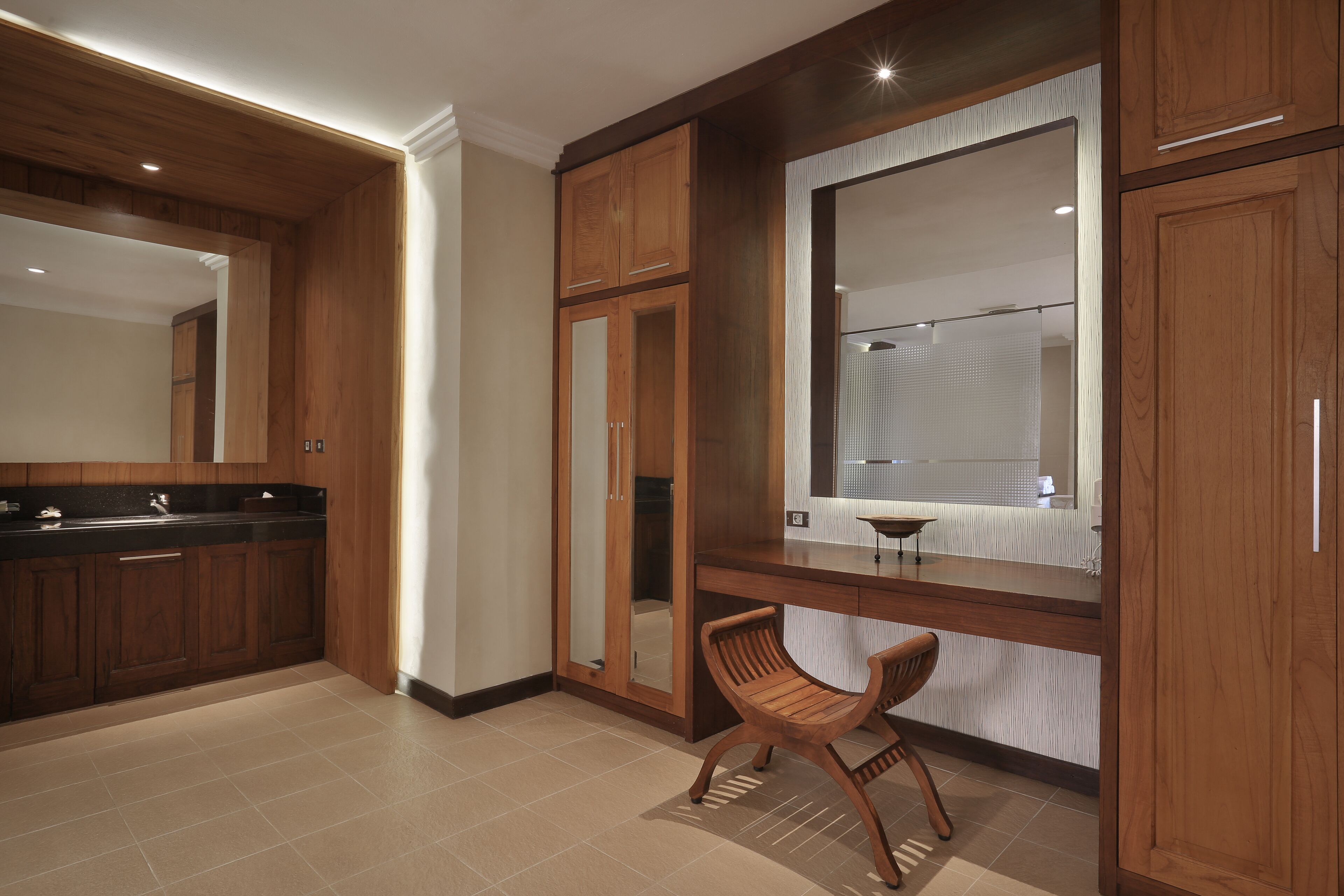 A modern bathroom with wooden cabinetry, a large mirror, and a built-in sink.