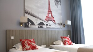A hotel room with two beds, a large painting of the Eiffel Tower, and a view of the sky through a window. - Avia Saphir Montparnasse (Paris)