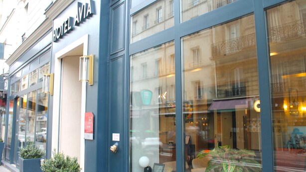 A hotel facade with large windows, a sign reading "HOTEL AVIA," and a door with a "H" sign indicating a handicap-accessible room. - Avia Saphir Montparnasse (Paris)