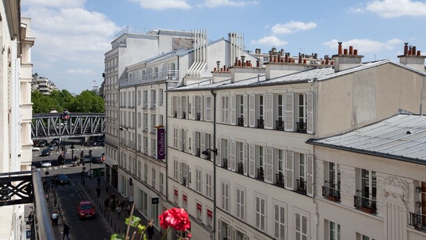 A multi-story building with white facades and shutters, featuring a pedestrian street below. - Hôtel Saphir Grenelle (Paris)