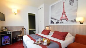 A hotel room with two beds, a desk, a refrigerator, and a wall-mounted TV. - Hôtel Saphir Grenelle (Paris)