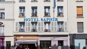 A hotel named HOTEL SAPHIR with a classic facade, multiple windows, and balconies with potted plants. - Hôtel Saphir Grenelle (Paris)