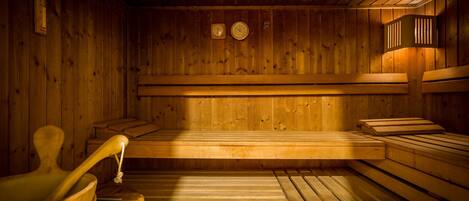 Una sauna de madera con bancos y un banco de madera en el suelo.