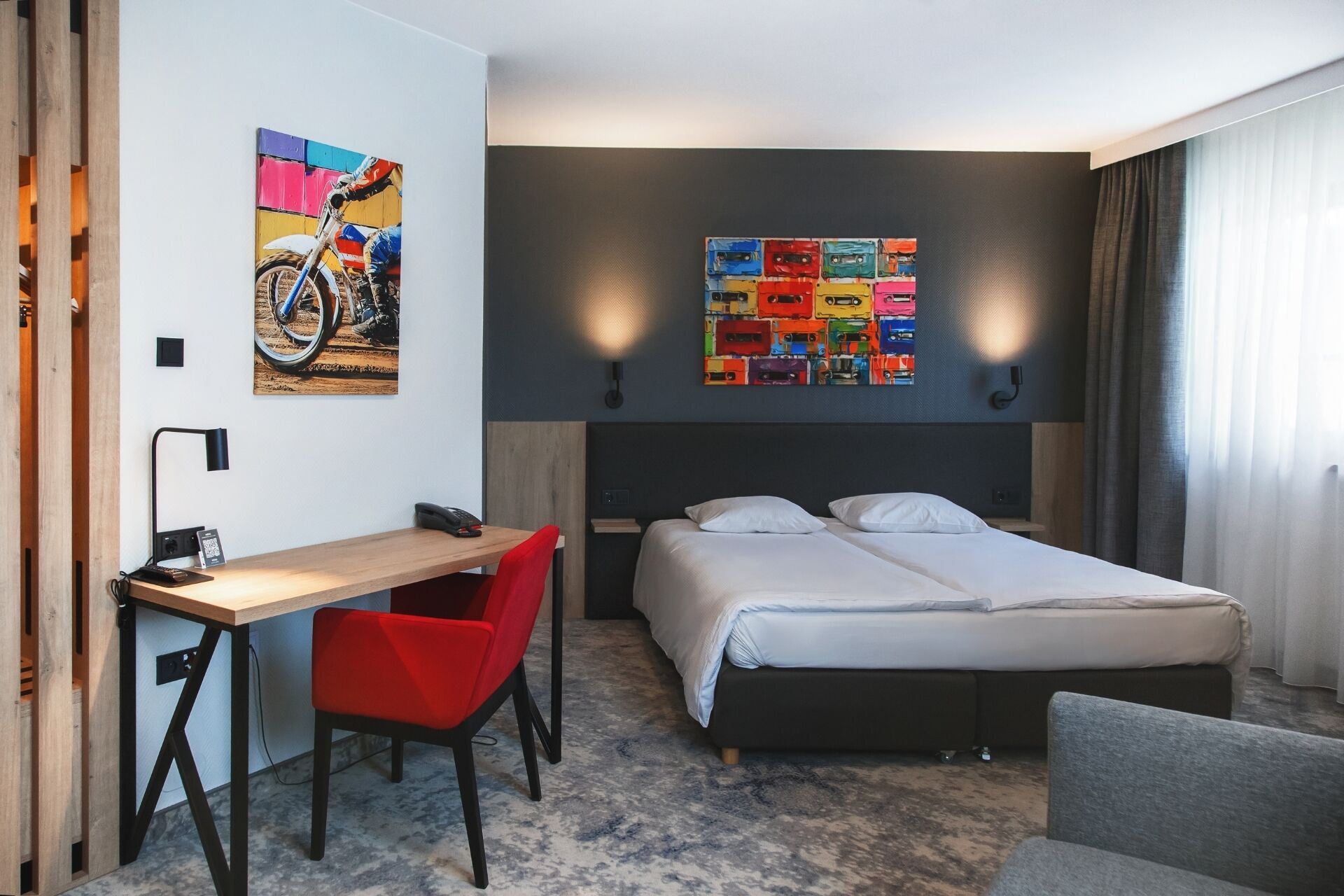 Une chambre d’hôtel moderne, équipée d’un lit, d’un bureau et d’une chaise.