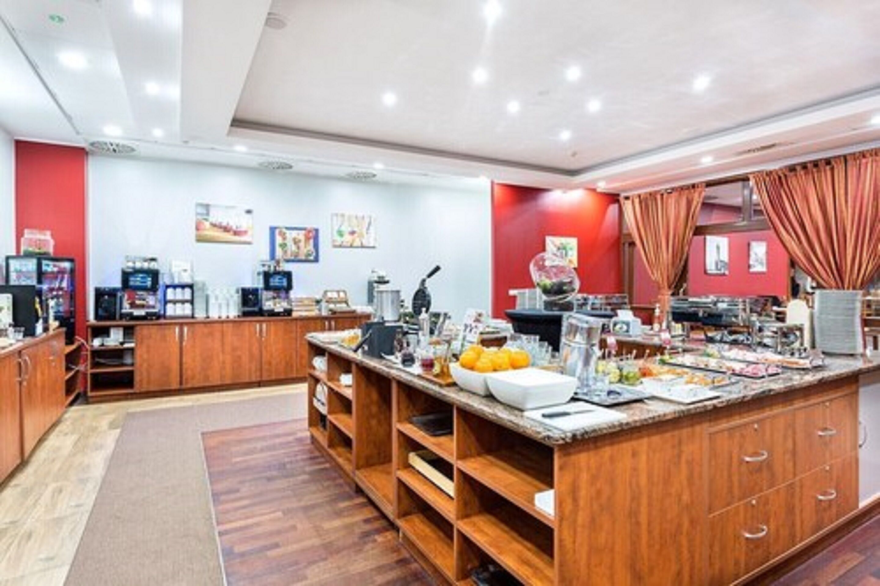 A buffet area with wooden cabinets, a marble counter, and various food items.