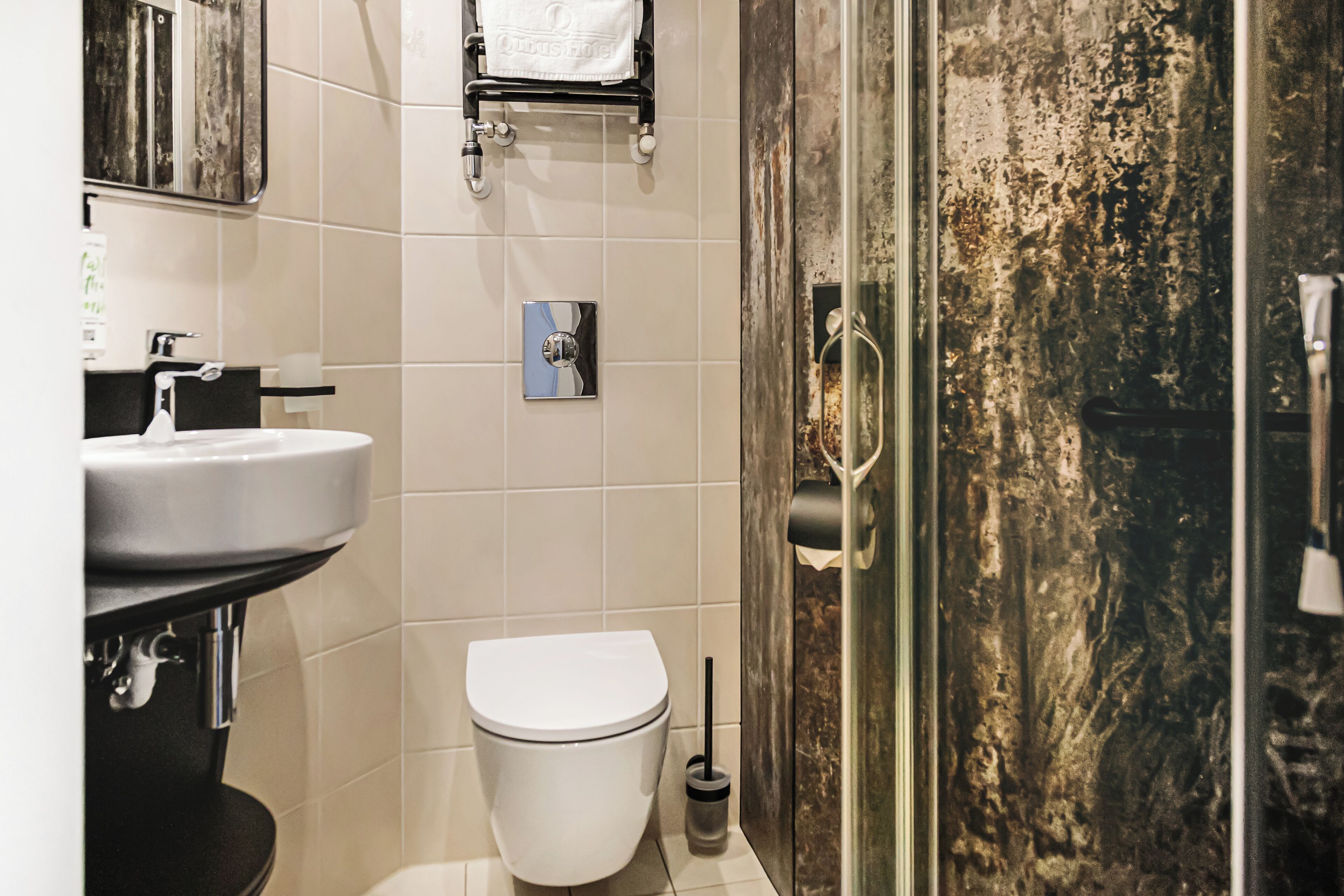 A modern bathroom with a white toilet, a sink, and a shower area.