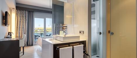 Un baño moderno con un espejo grande, ducha y vistas al exterior.