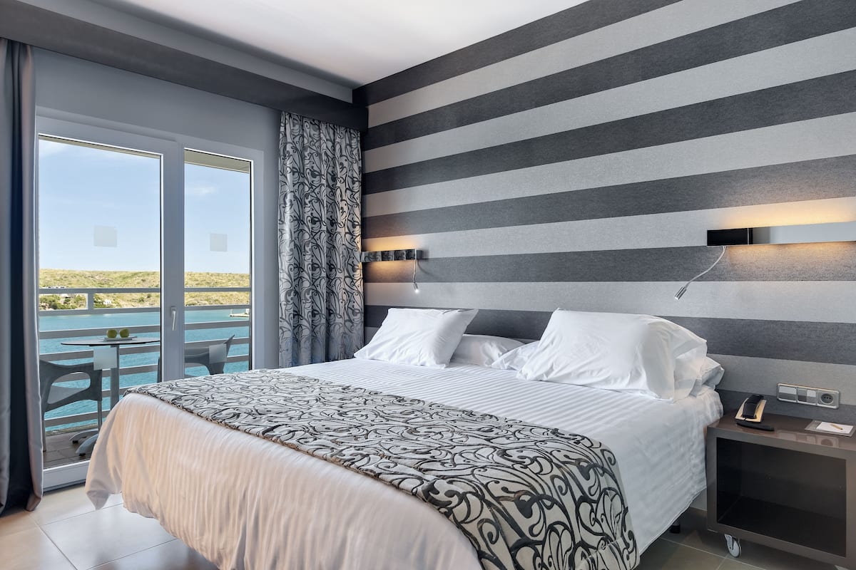 Une chambre d’hôtel dotée d’un grand lit, d’un balcon avec vue et d’un design moderne.