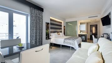 Una habitación de hotel moderna con cama, escritorio, sofá y televisión.