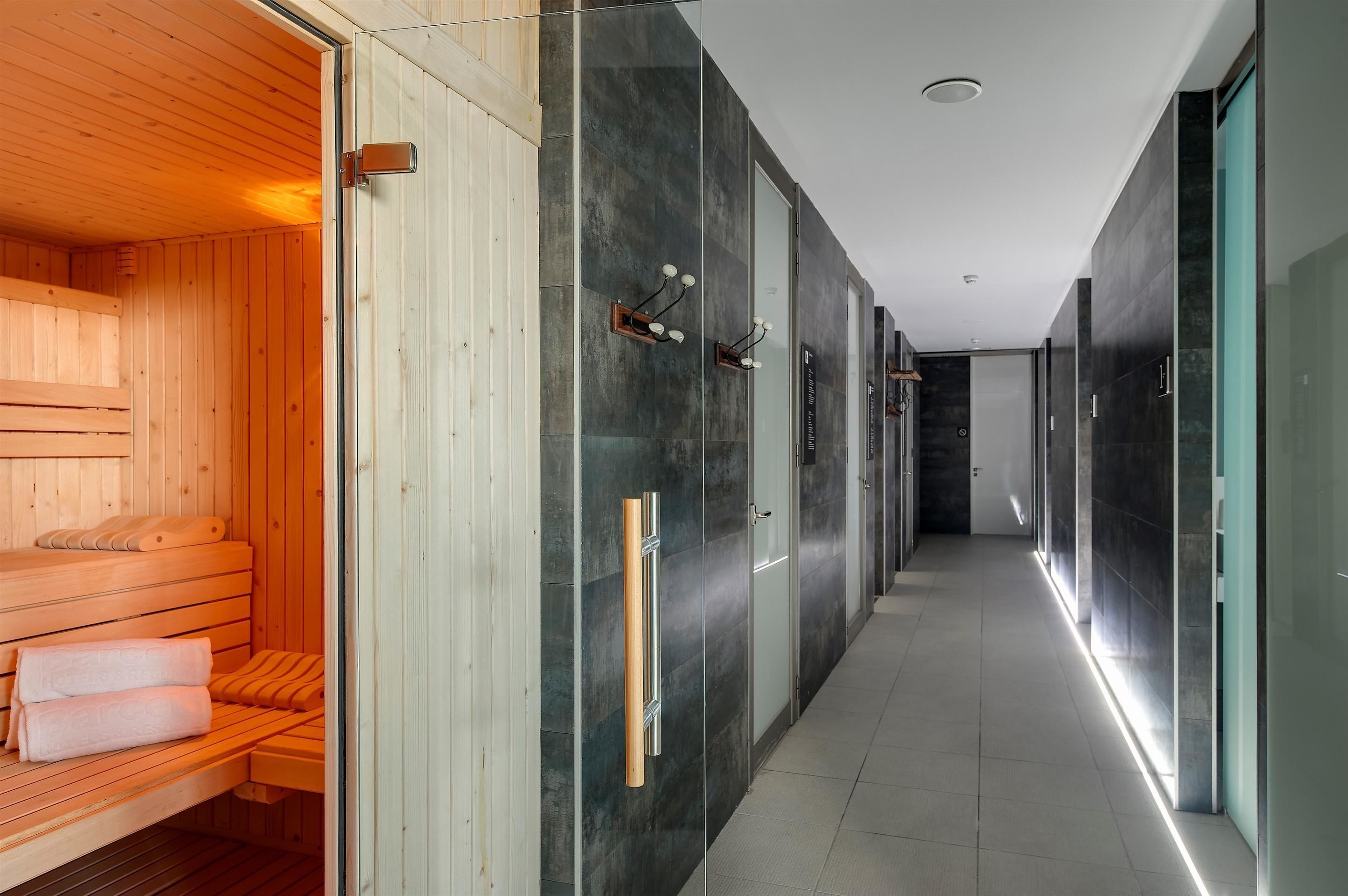 A modern spa area with wooden benches and a glass wall.