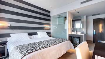 Une chambre d’hôtel moderne équipée d’un grand lit, d’un bureau et d’un mini-bar.